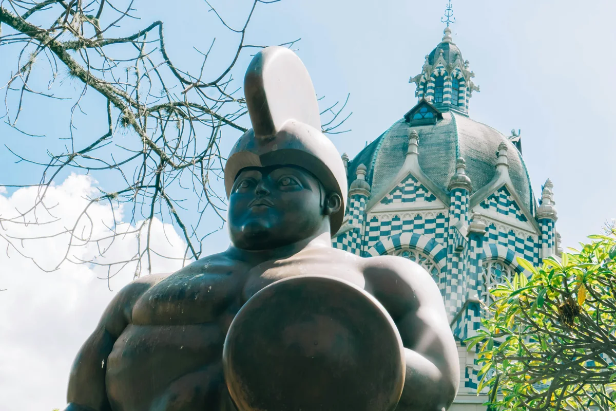 Escultura en Medellín con arquitectura histórica al fondo