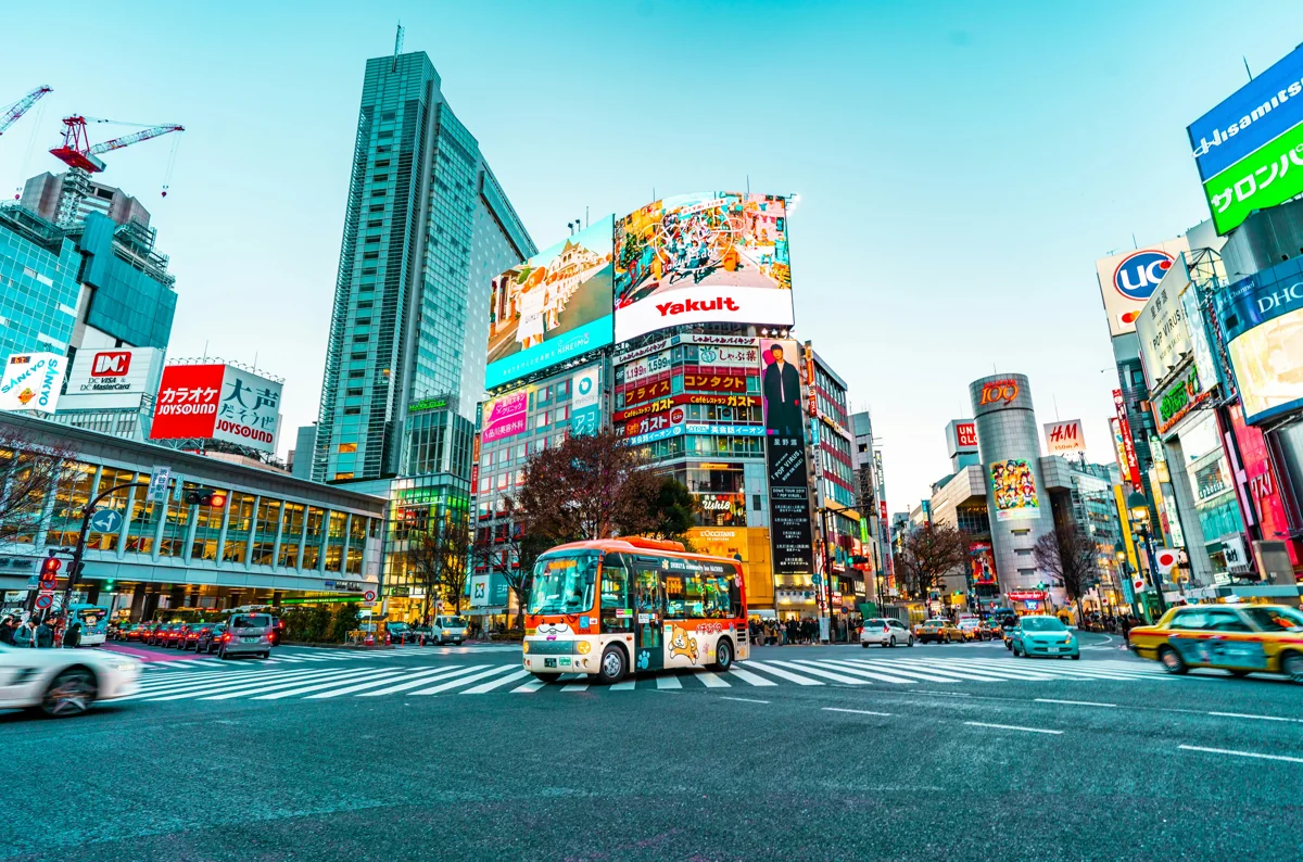 Cruce urbano de Tokio con edificios, letreros y tráfico
